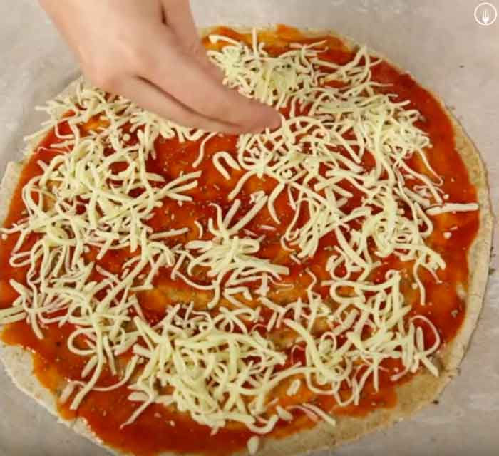 Pizza integral con mozzarella, tomate y pesto